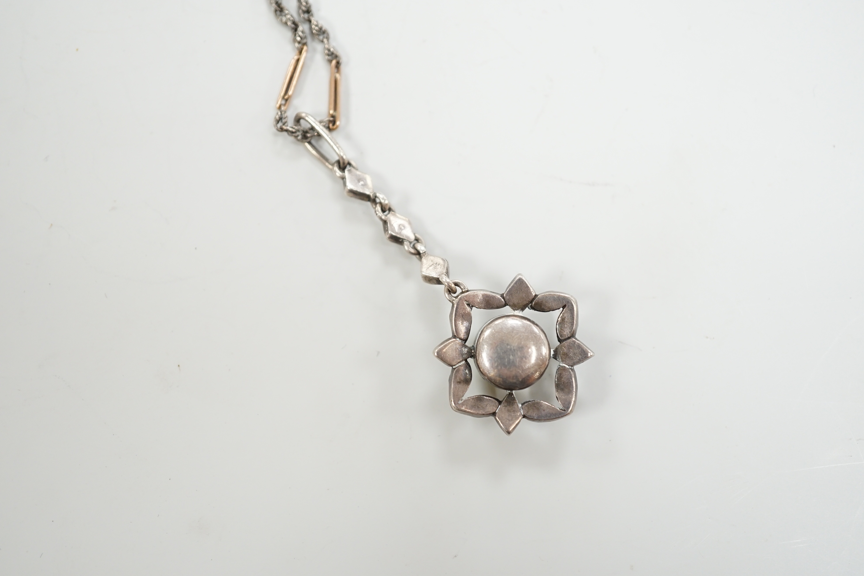 A 19th century white metal and foil backed paste set pendant, 40mm, on a later two colour chain, the clasp stamped 9ct.